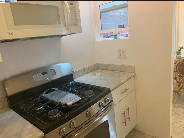 a stove top oven sitting inside of a kitchen