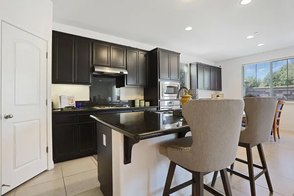 a kitchen with kitchen island granite countertop a sink cabinets and refrigerator