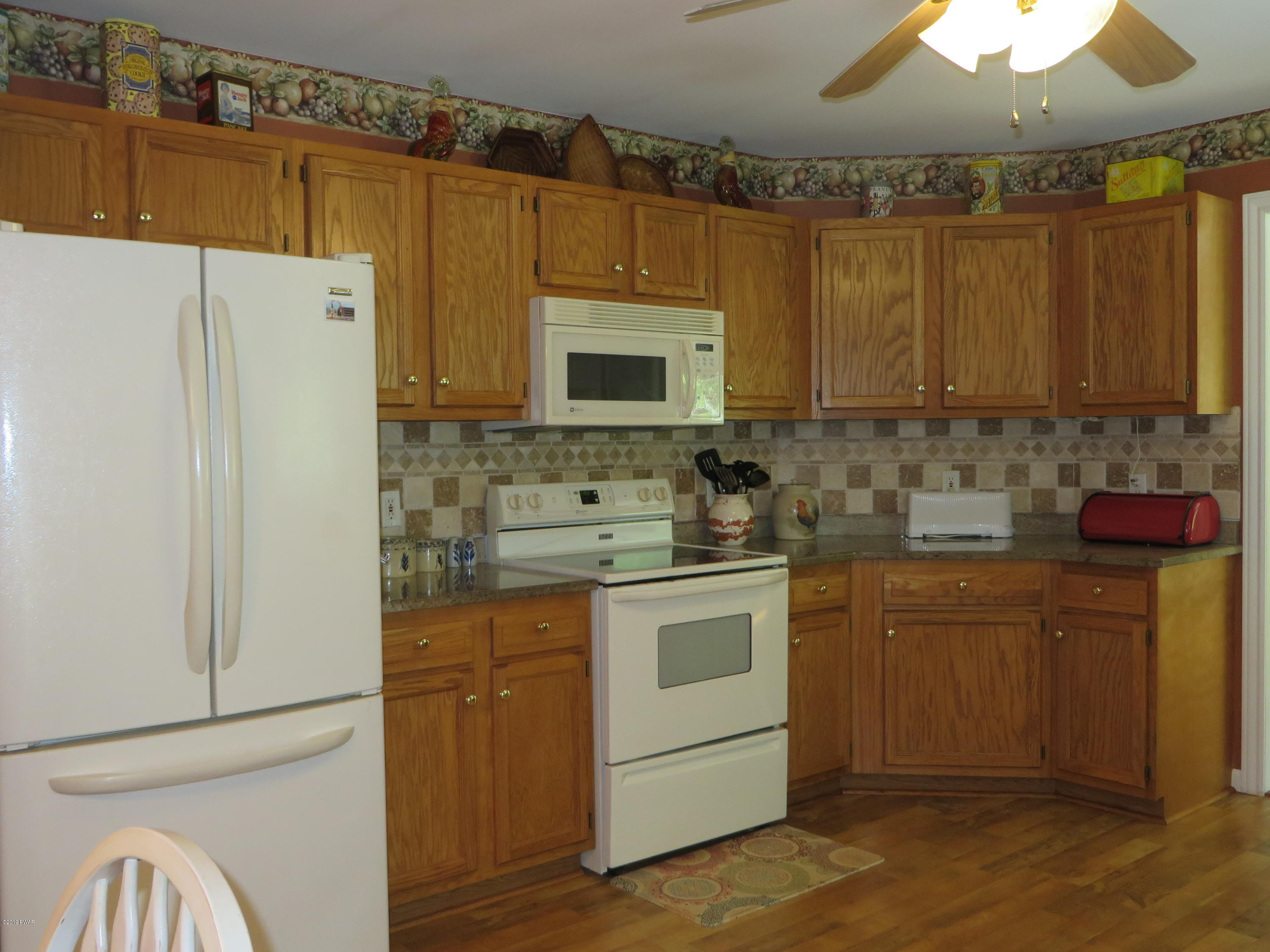 137 Maple Ridge Road Milford, PA 18337 - Photo 21 of 82 a kitchen with stainless steel appliances granite countertop a refrigerator a stove a sink and white cabinets with wooden floor