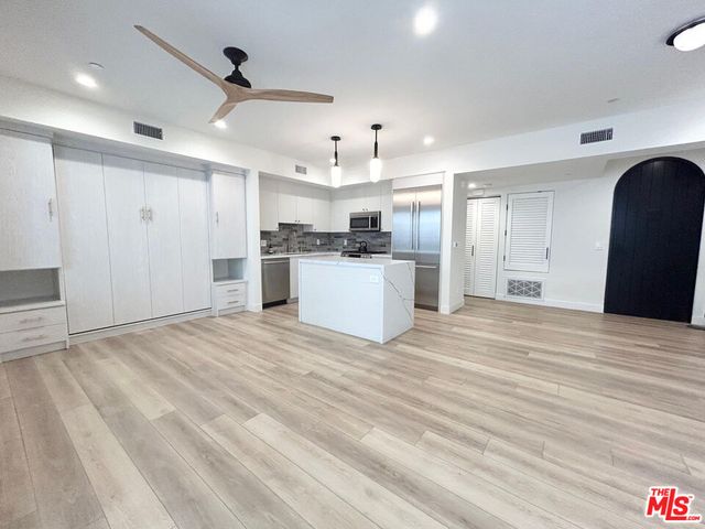 a view of a kitchen with a sink and a refrigerator