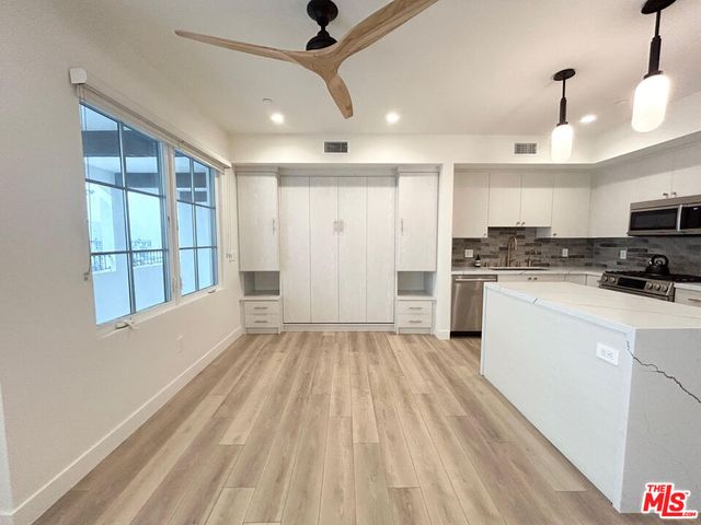 a view of kitchen with wooden floor and electronic appliances