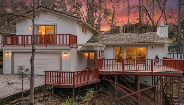 a view of a house with a deck and furniture