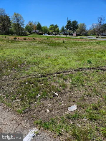 a view of a green field with wooden fence