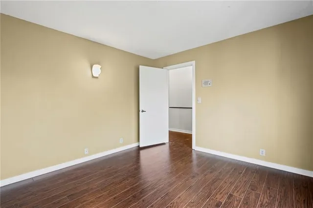 a view of a livingroom with wooden floor and a bathroom