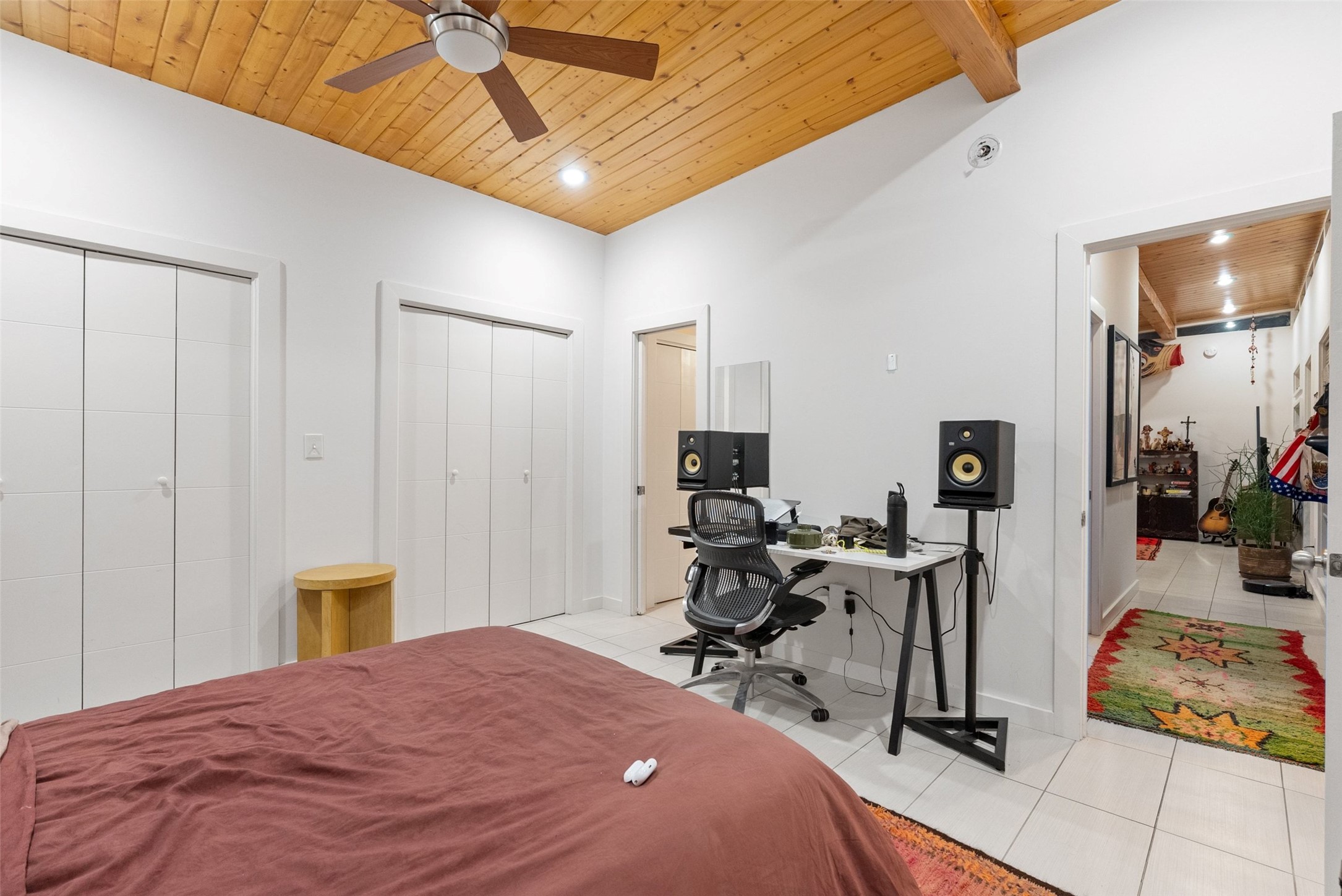 412 West Croslin Street Austin, TX 78752 - Photo 28 of 36 A versatile bedroom offering both comfort and a dedicated workspace, featuring a warm wood-paneled vaulted ceiling.