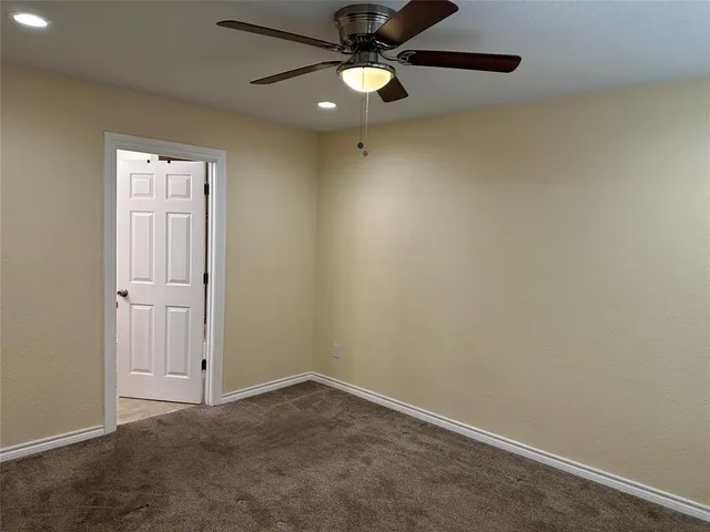 an empty room with closet and a chandelier fan