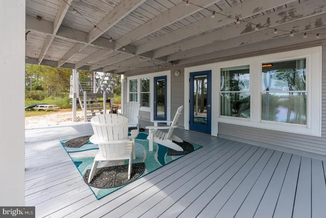 a view of a patio with table and chairs wooden floor