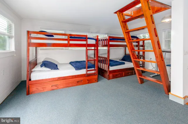 a bedroom with a bed lamp and a large window