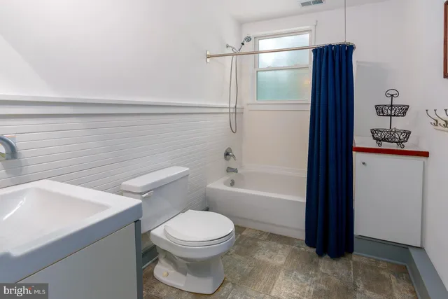 a bed sitting in a bedroom next to a window with tv