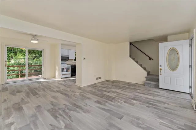 a view of empty room with wooden floor and window