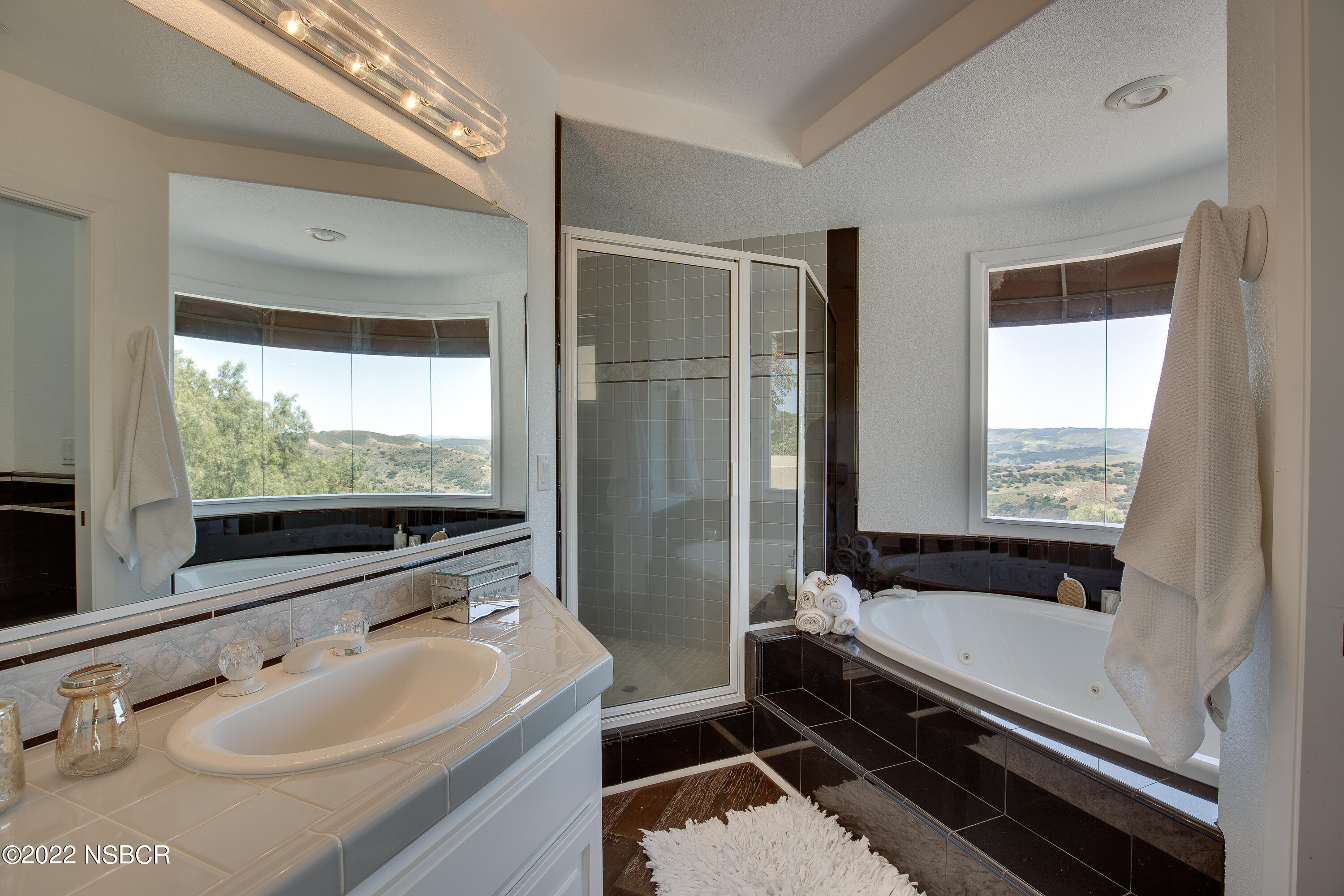 1833 Cougar Ridge Road Buellton, CA 93427 - Photo 25 of 46 a bathroom with a tub a sink and a large mirror