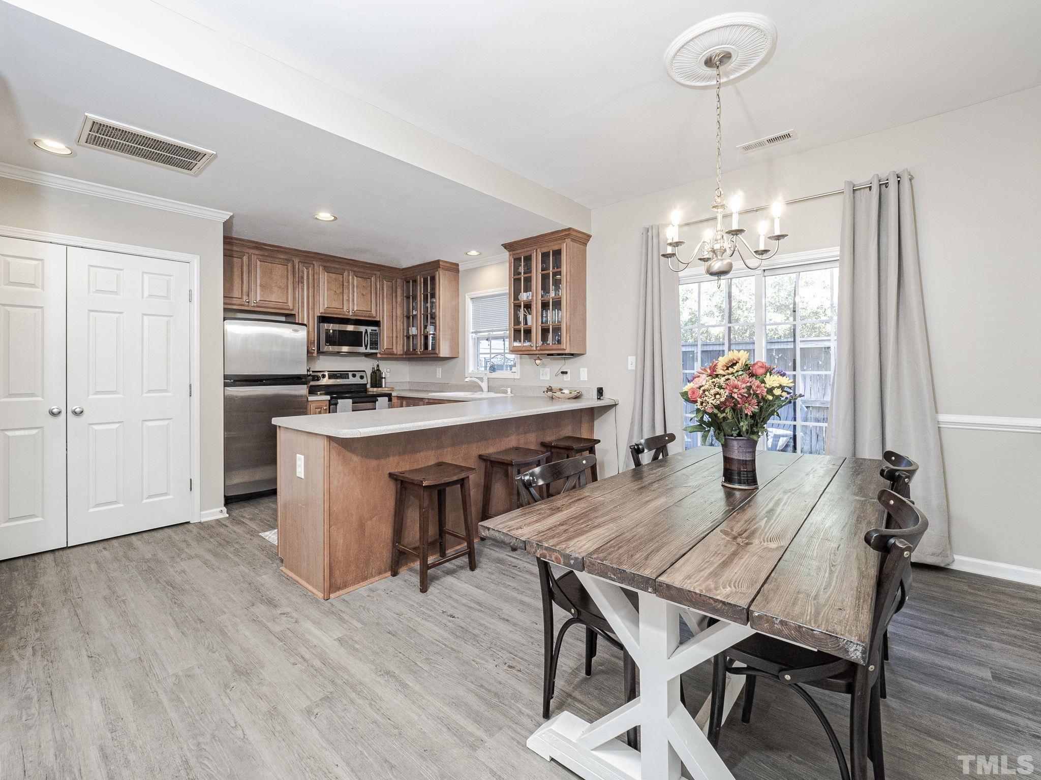 2031 Rivergate Road, Unit 106 Raleigh, NC 27614 - Photo 6 of 11 a dining room filled chandelier and wooden floor