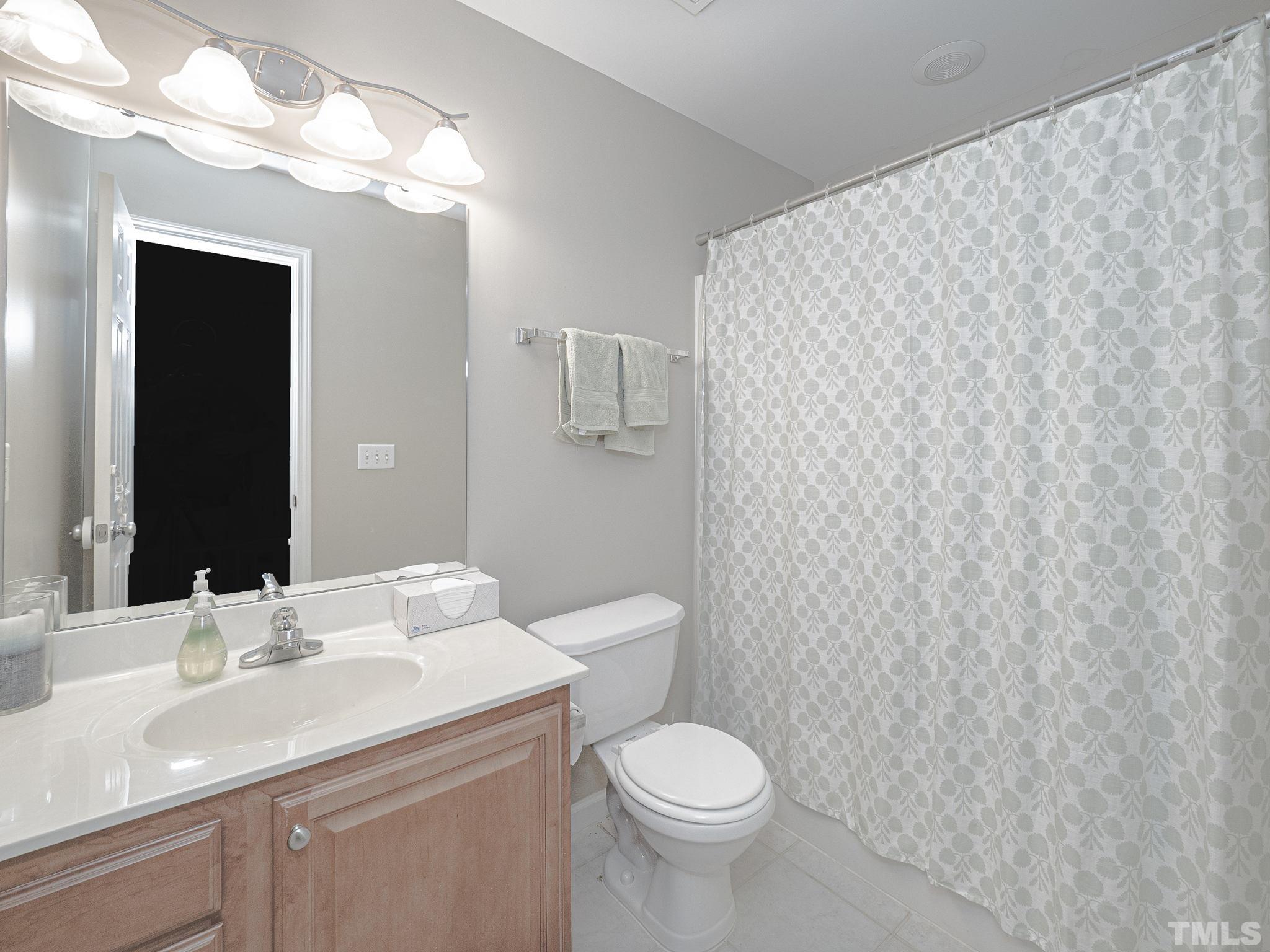 2031 Rivergate Road, Unit 106 Raleigh, NC 27614 - Photo 8 of 11 a bathroom with a toilet a sink and mirror