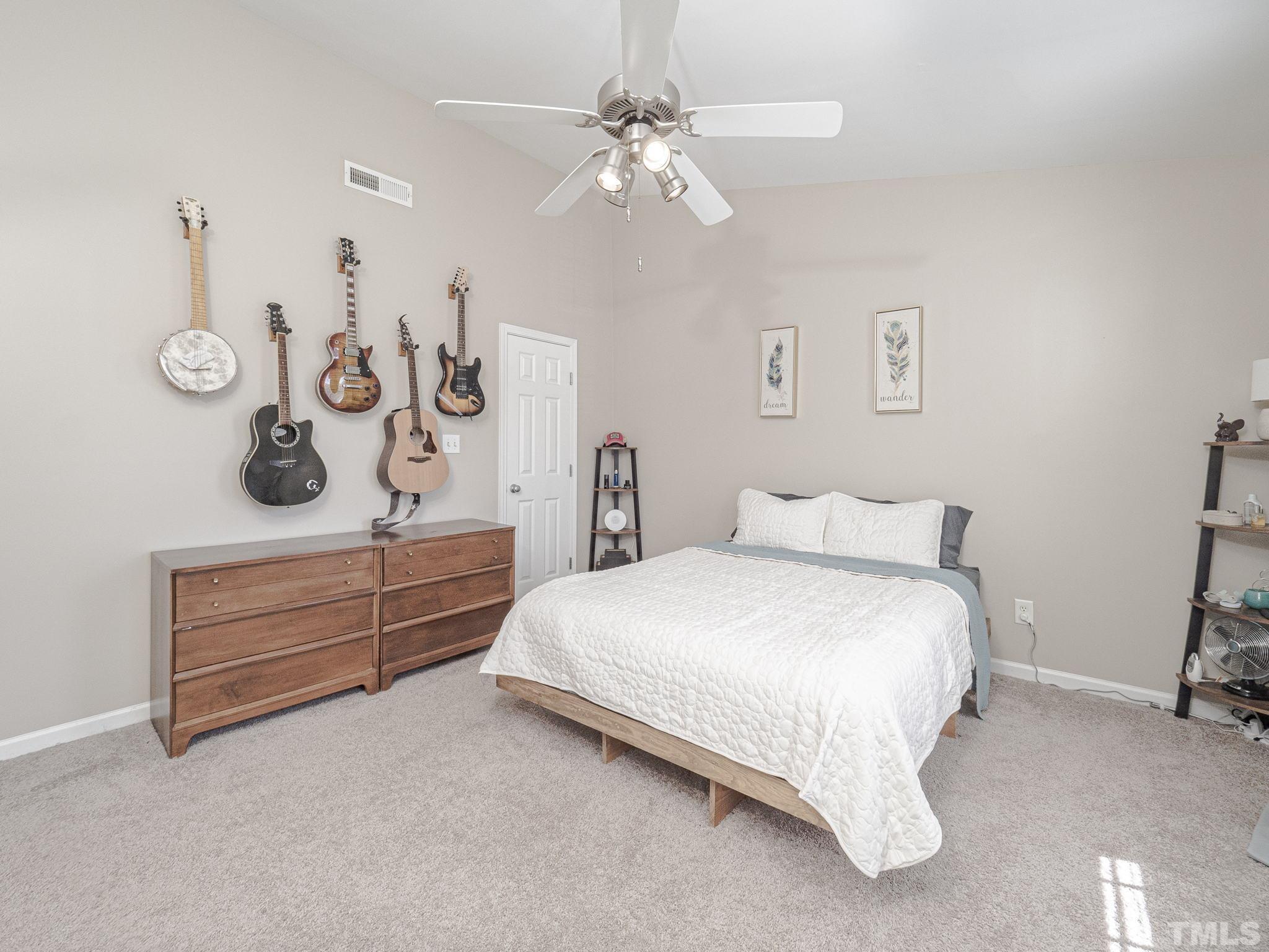 2031 Rivergate Road, Unit 106 Raleigh, NC 27614 - Photo 9 of 11 a bedroom with a bed and a chandelier