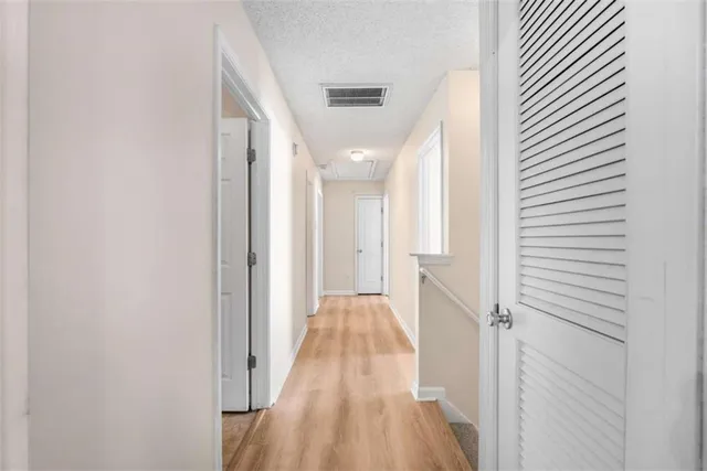 a view of a hallway with wooden floor and staircase