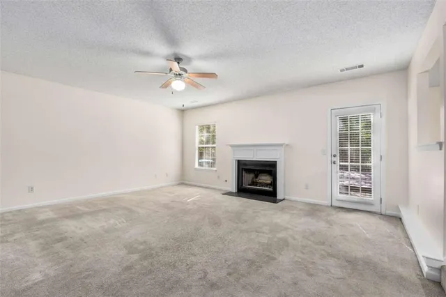 an empty room with windows and fireplace
