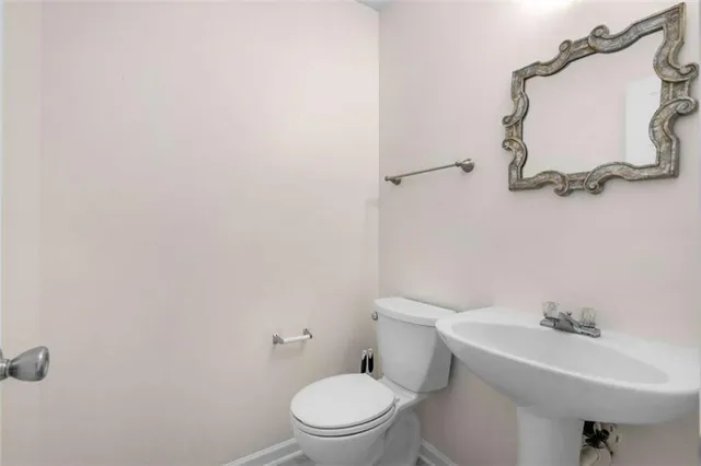 a white toilet sitting next to a bathroom sink
