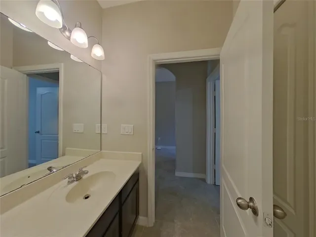 a bathroom with a sink a light fixture and a mirror