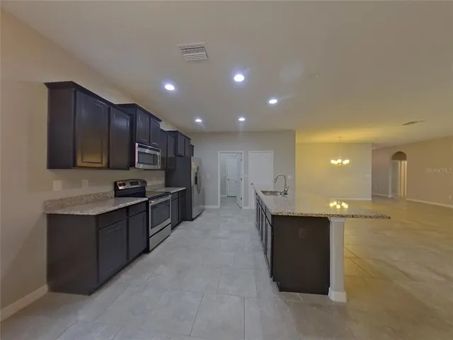 a kitchen with stainless steel appliances a sink stove and cabinets
