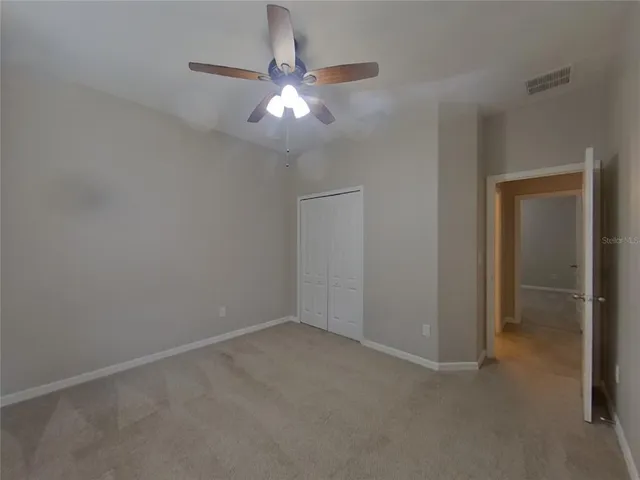 an empty room with a chandelier fan