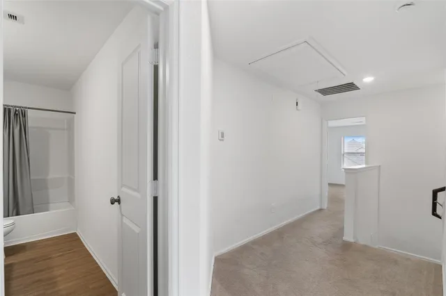 a view of a hallway with wooden floor and closet area