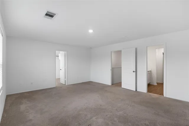 a view of an empty room and chandelier fan
