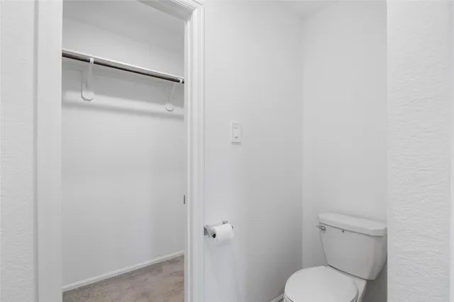 a white toilet sitting next to a shower