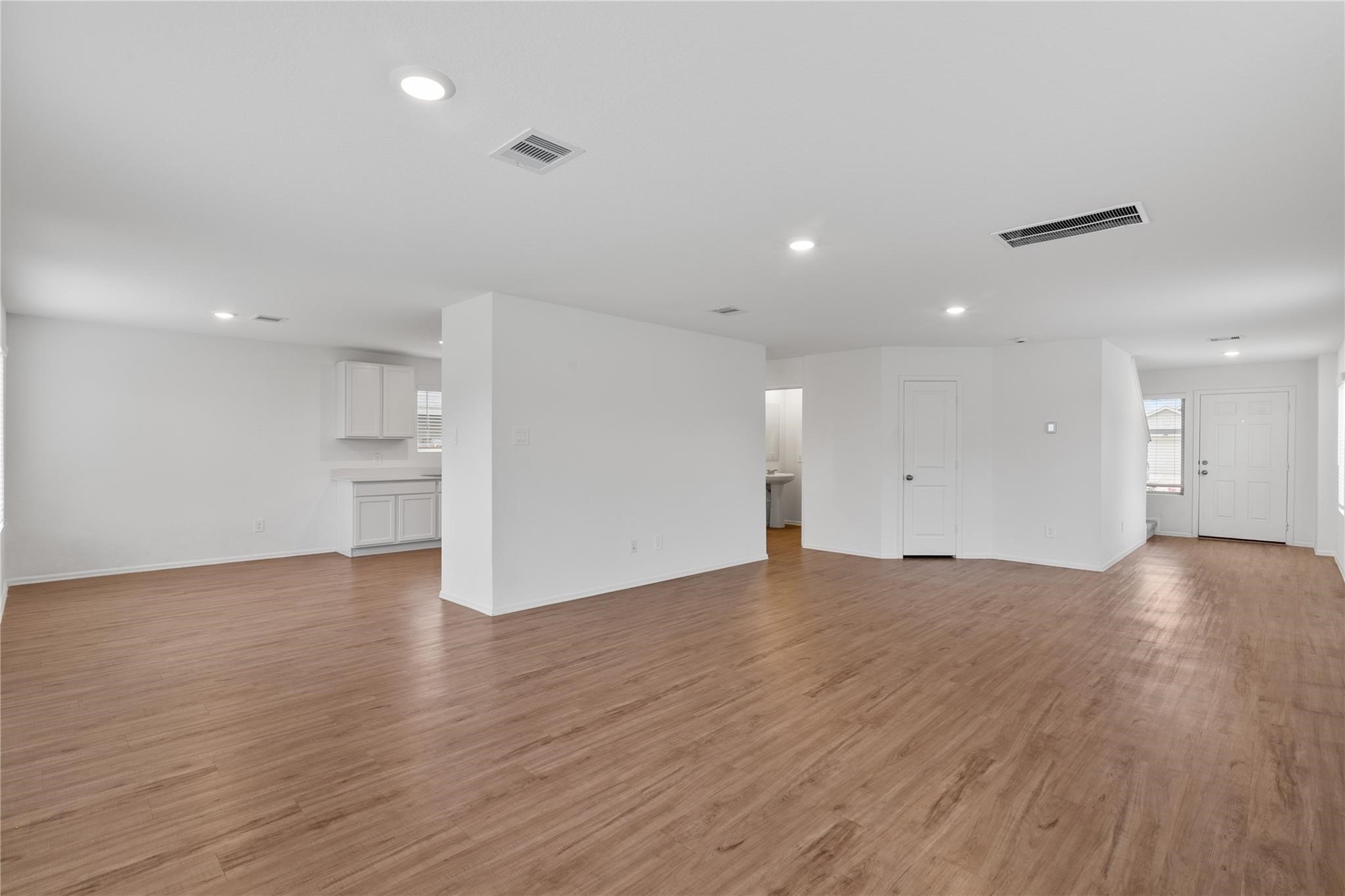 3034 Twisted Myrtle Drive Conroe, TX 77301 - Photo 4 of 27 a view of an empty room with wooden floor and kitchen