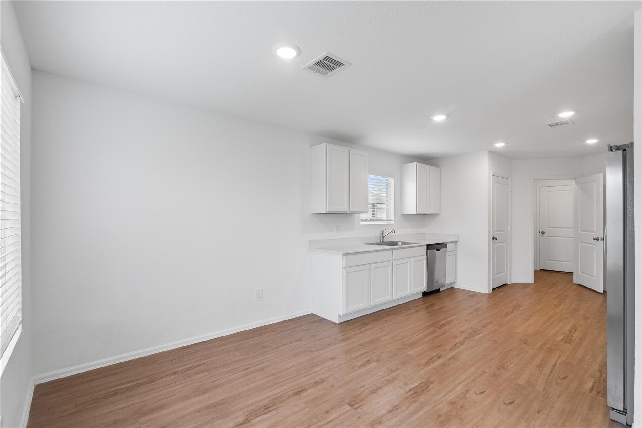 3034 Twisted Myrtle Drive Conroe, TX 77301 - Photo 6 of 27 a view of a kitchen with a sink and dishwasher a stove top oven with wooden floor