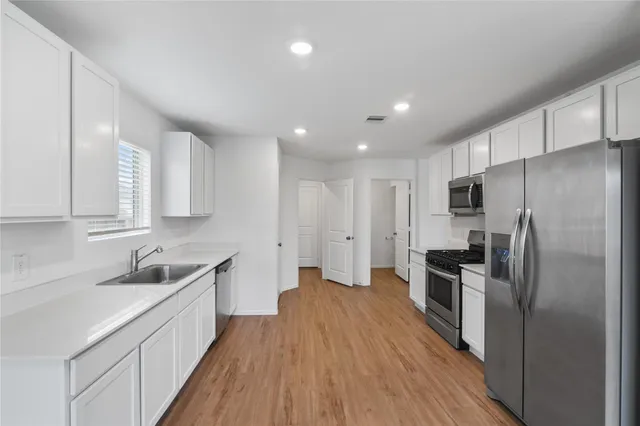 a kitchen with cabinets and stainless steel appliances
