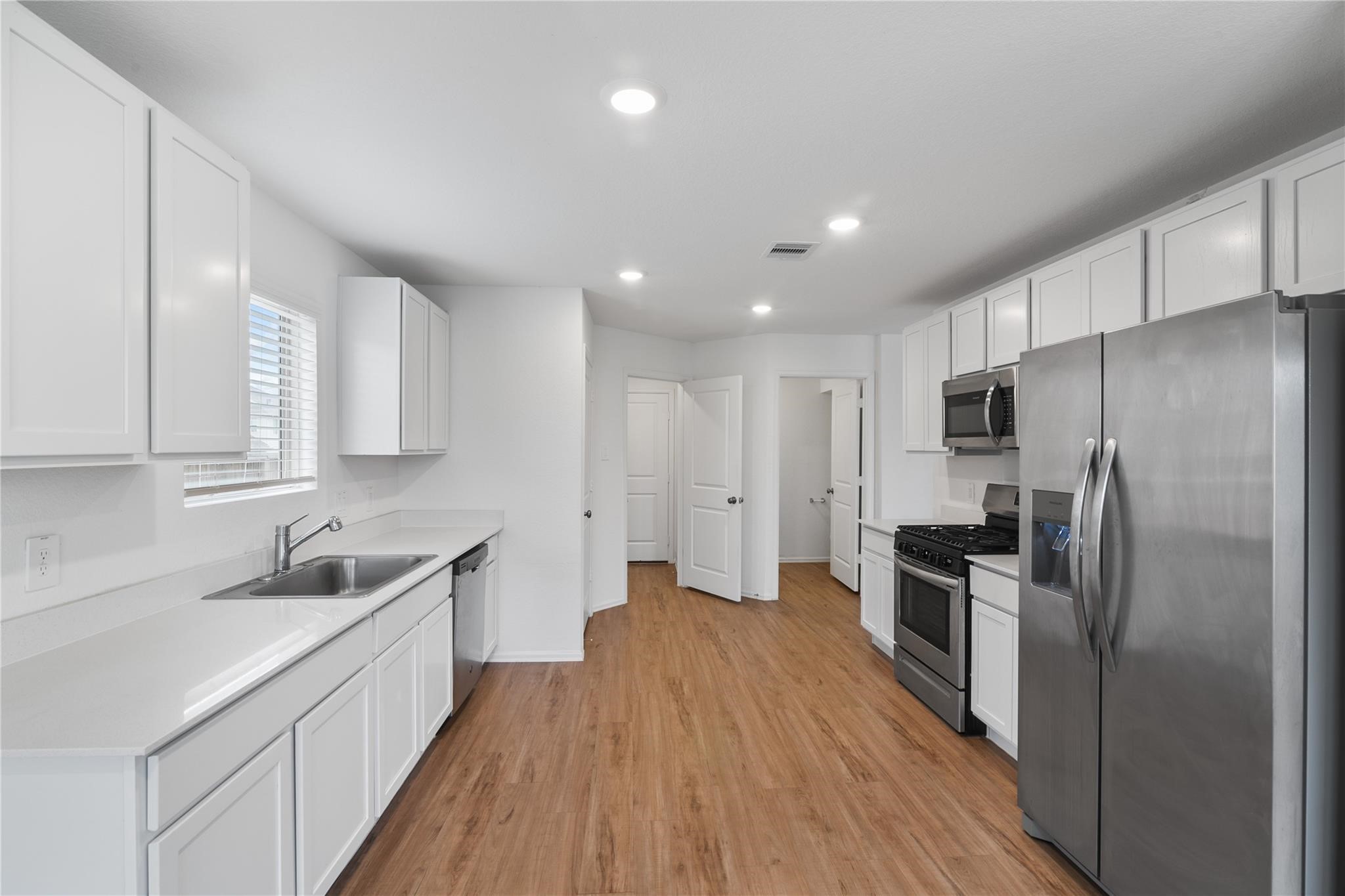 3034 Twisted Myrtle Drive Conroe, TX 77301 - Photo 7 of 27 a kitchen with cabinets and stainless steel appliances