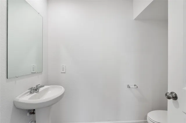 a bathroom with a sink a toilet and mirror