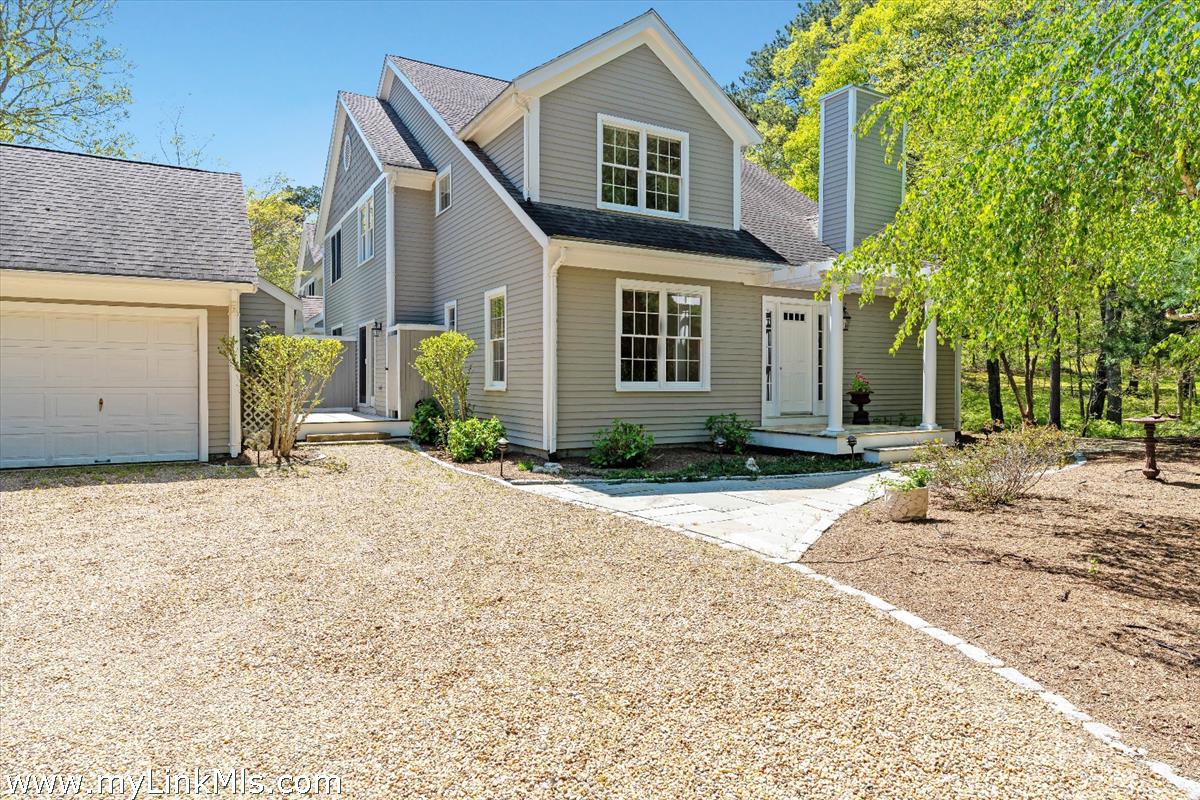 261 Sandpiper Lane, Unit 12 Vineyard Haven, MA 02568 - Photo 2 of 50 a front view of a house with a yard and garage