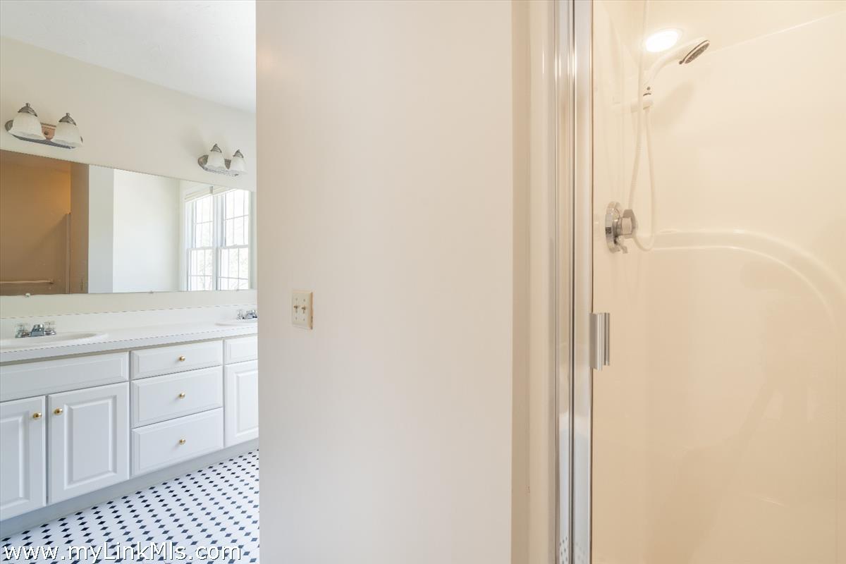 261 Sandpiper Lane, Unit 12 Vineyard Haven, MA 02568 - Photo 25 of 50 a bathroom with a sink a mirror and a shower