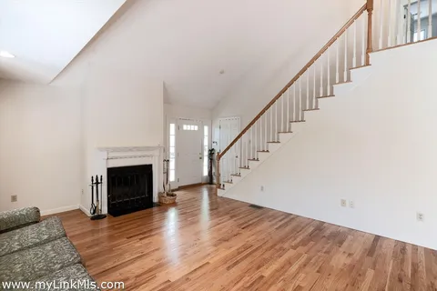 a view of empty room with wooden floor and fireplace