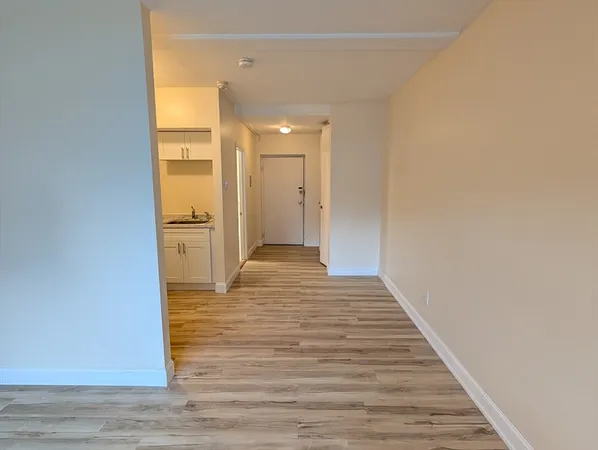 a view of a hallway with wooden floor
