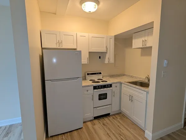 a white refrigerator freezer and a stove sitting inside of a kitchen