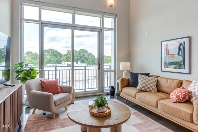 a living room with furniture and a dining table with garden view