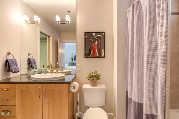 a bathroom with a sink a toilet a mirror and shower