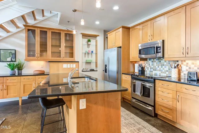 a kitchen with stainless steel appliances granite countertop a sink stove and refrigerator