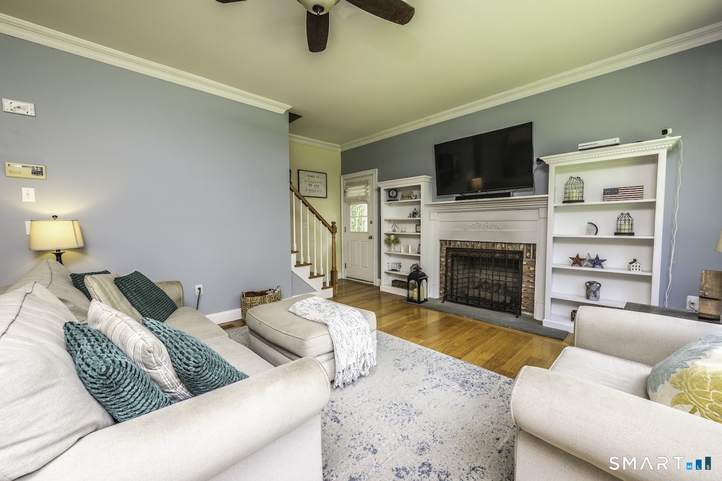 76 R Ivy Way Durham, CT 06422 - Photo 4 of 19 Bright and welcoming family room with hardwood floors, a classic fireplace, and custom built-in shelving.