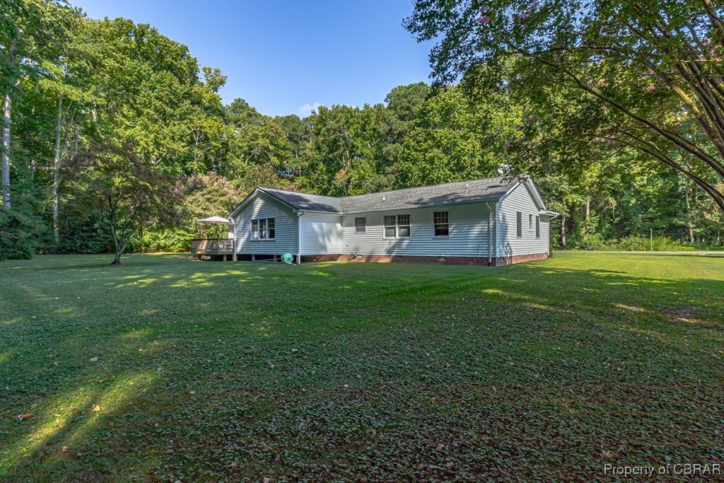 35 Powhatan Road Kilmarnock, VA 22482 - Photo 40 of 42 Rear view of house with a lawn, a wooded view, and a deck