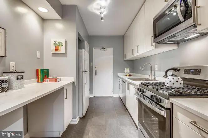 4141 North Henderson Road, Unit 322 Arlington, VA 22203 - Photo 12 of 53 a kitchen with stainless steel appliances a sink stove and refrigerator