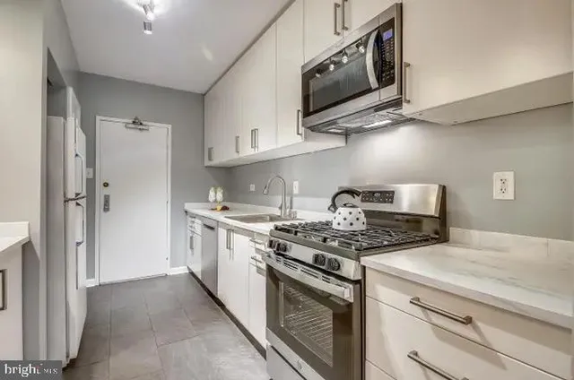 a kitchen with stainless steel appliances granite countertop a stove and a refrigerator