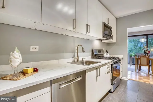 a kitchen with stainless steel appliances a sink a stove and cabinets