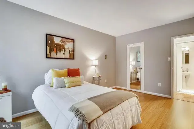 a bedroom with a bed and wooden floor