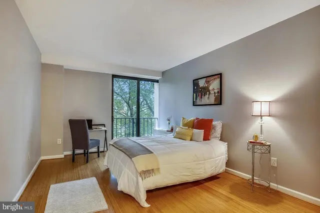 a bedroom with a bed a lamp on table and a window