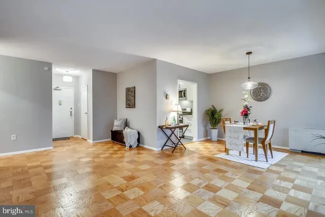 a living room with furniture a dining table and a potted plant