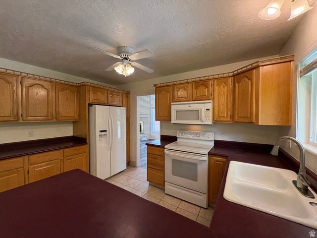 595 Meadowlark Road Orem, UT 84097 - Photo 16 of 87 Kitchen featuring wood-finish cabinetry, white appliances, and a ceiling fan with integrated lighting