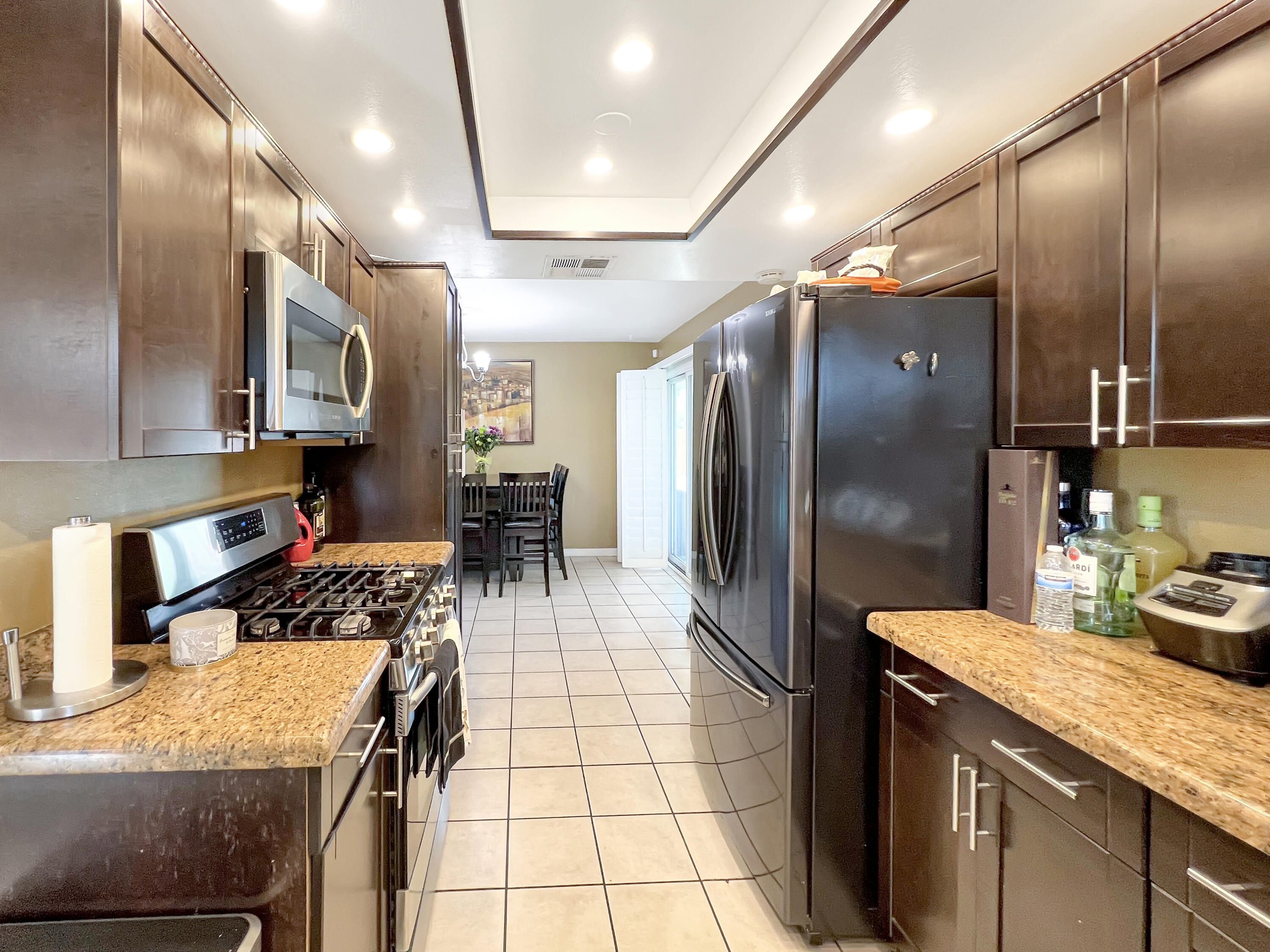 44590 Roundtable Street Indio, CA 92201 - Photo 8 of 16 a kitchen with stainless steel appliances granite countertop a sink a stove a refrigerator a washer dryer and a dining table